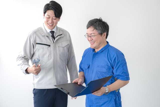 資料を見て笑う作業員二人
