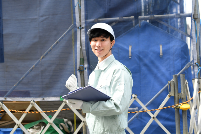建設現場でガッツポーズをする笑顔の作業員